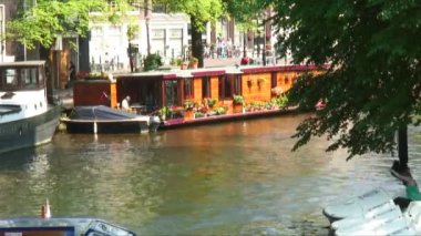 Amsterdam, Hollanda - 2013 yaklaşık: Sahne görünümü bir tekne-evi Hollanda önünde girdiği bir feribot ile Amsterdam'da bir kanal.
