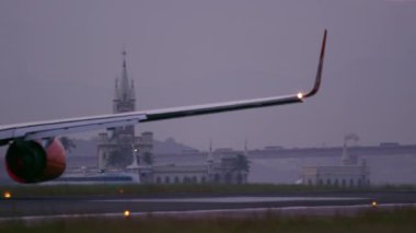 Rio De Janeiro, Brezilya - 21 Haziran 2013: Brezilya'nın Rio de Janeiro şehrindeki Jacarepagua havaalanından kalkan Tam havayollarına ait bir uçuşu takip eden panning fotoğrafı. Tekne ve araba gibi diğer hareketli nesneler arka planda görülebilir.