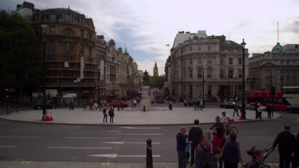 2011年10月9日 特拉法加广场旁的环形路和远处的大本钟和建筑物 一个静止的街道交通镜头 有人试图过马路 大红色的公共汽车通过相当接近相机 — 图库视频影像