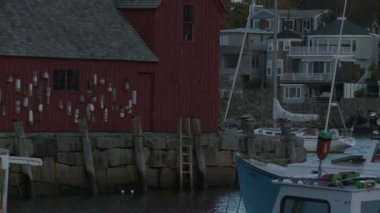 Sundown Rockport limanın Motif numarası 1, ünlü kırmızı balıkçı kulübesi Bradley Wharf üzerinde kaydırma atış. Demirli tekneler ve oceanside ev ve işyerleri vardır. Rockport, Massachusetts.