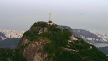 Rio De Janeiro, Brezilya - Haziran 2013: Kurtarıcı İsa'nın arka görünümüyle ünlü Corcovado dağının havadan görünümü. Görüntülerde arka planda atlanktik okyanus ve Rio de Janeiro şehri yer alıyor. Gökyüzü gri.