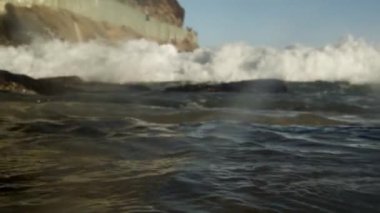 Kayalar ve kamera Atlantik Okyanusu statik bir kadeh. Atış bir uçurum yakalar ve Rio de Janeiro'nun Haziran gelgit. Görüntüleri karanlık olana kadar dalga kamera merceği sürüleri.