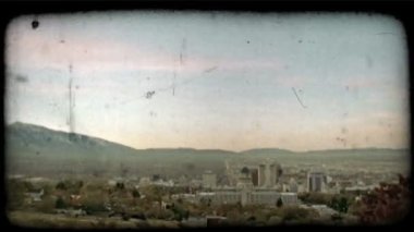 Şehir merkezi Salt Lake City yavaş tava uyanır ve gece ışıkları solmaya başlar, Wasatch Sıradağları'nın arka tarafında. Vintage stilize video klip.