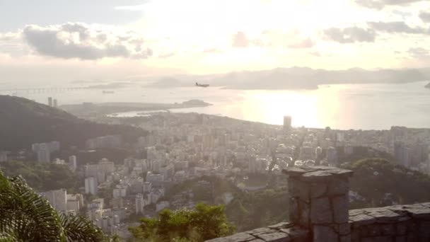 ブラジルのリオデジャネイロの展望地点からパンニングショット カメラ パンは 遠くの平面に従って左から右に形成されます ショットでは 街全体のほとんどが見えるだけでなく 湾です — ストック動画