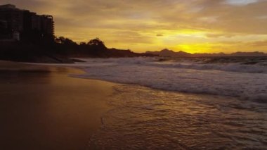 Yavaş-mo, gelgit devil's beach (Praia do Diabo) arka planda Rio De Janeiro şehir manzarası ile alacakaranlıkta gelir gibi çöken dalgaların çekim izleme