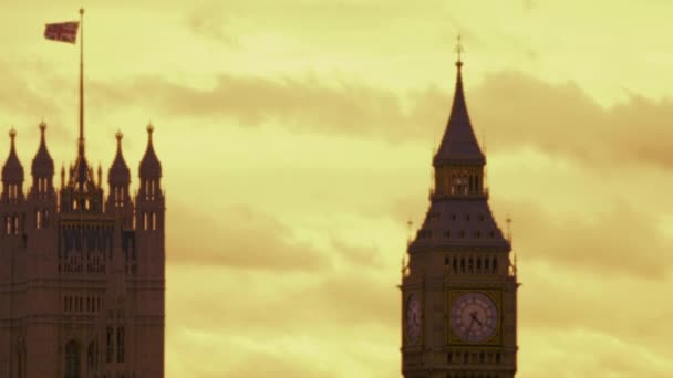 相机起价的国旗飘扬在威斯敏斯特宫和大笨钟的钟塔和下行逐渐 揭示亨格福德大桥 一列火车的跨越 — 图库视频影像
