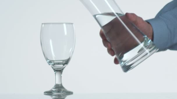 空的酒杯满水从滗水器的手的特写慢动作 — 图库视频影像