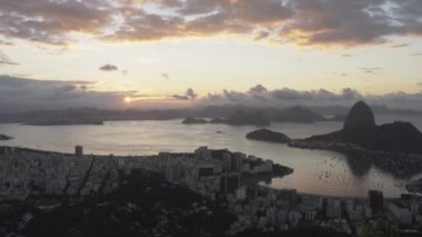 Bir atış, Rio de Janeiro şehrine gün batımı sırasında. Kamera tava sağdan yavaş yavaş yaptı. Şehir ve bay görünümünde çerçevenin alt yarısında, ve dağlar mesafe kontrast.