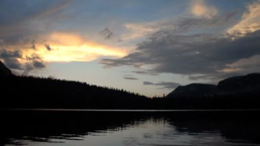 Geniş timelapse silhouette dağ Gölü ve gün batımından bulutlara