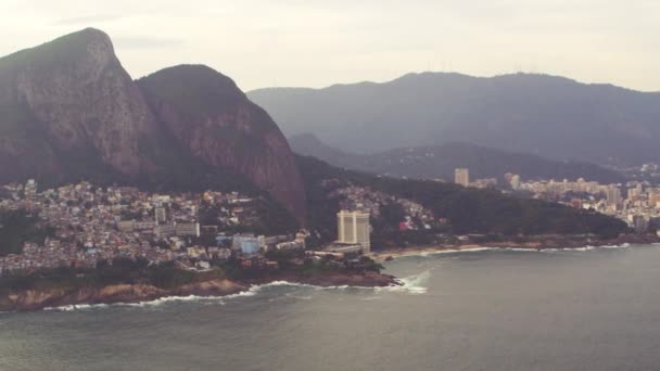 山と街のリオデジャネイロ レンズのフレアとブラジルの貧民街の空中パン ショット この映像はヘリコプターから撮影されました — ストック動画