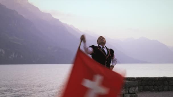 Homme Tourne Lance Drapeau Suisse Tout Tenant Près Joueur Alphorn — Video