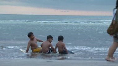 Bali, Endonezya - 2013 yaklaşık: Geniş kumsalda oturan genç erkek vurdu.