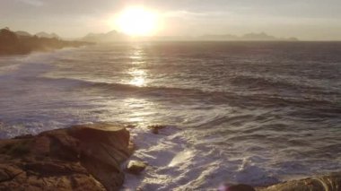 Bu, Ipanema Plajı'nda kıyıboyunca yuvarlanan dalgaların çoğunlukla statik bir fotoğrafı. Güneş okyanusun üzerinde doğar..