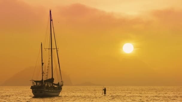 スタンド アップ パドル ボード ブラジル ジャネイロのボートへの移動の男 日没時に撮影されたビデオ — ストック動画