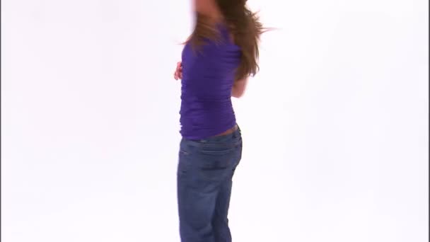 紫のシャツとジーンズで踊っている女の子のショットを傾けてください — ストック動画