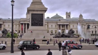 Londra, İngiltere - 11 Ekim 2011: Trafalgar Meydanı önünde sokak sabit görünümü, kimliği belirsiz insanlar dolaşmak ve araba londra pirinç aslan heykelleri ve çeşme geçerek sokakta sürücü, İngiltere.
