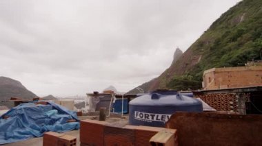Rio De Janeiro, Brezilya - 23 Haziran 2013: ağır çekim favela Rio de Janeiro, Brezilya için pan. Bazı metal artıkları, su deposu, evler ve insanlar video kamera tava soldan sağa olarak görülüyor