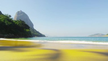 Rio Red Beach (Praia Vermelha) tropikal altın kumları üzerinde yıkama dalgalarıyavaş hareket çekim.
