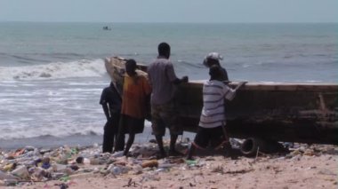 Sahilde teknesi olan insanların geniş bir görüntüsü.