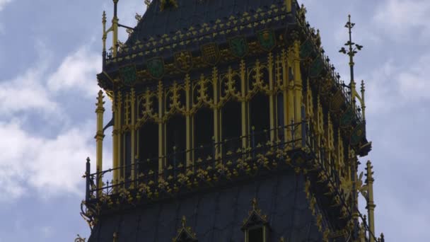 伦敦大本钟楼上部的特写 摄像机在塔上缓慢向下移动 看不到时钟部件 被蓝天和云彩包围 — 图库视频影像