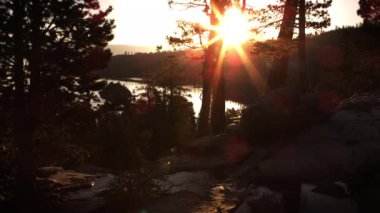 Alacakaranlık dere çekimi. Güneş ışınları ağaçların arasından görülebilir. Emerald Bay State Park, Lake Tahoe, Kaliforniya'da vuruldu.