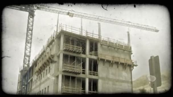 Высокий Кран Медленно Движется Углом Вырисовывается Над Зданием Цементной Рамке — стоковое видео