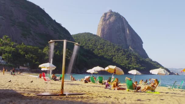ジャネイロ 2013 日当たりの良いリオの赤を楽しんでいる人のスローモーション撮影ビーチとの距離でシュガーローフ山 — ストック動画