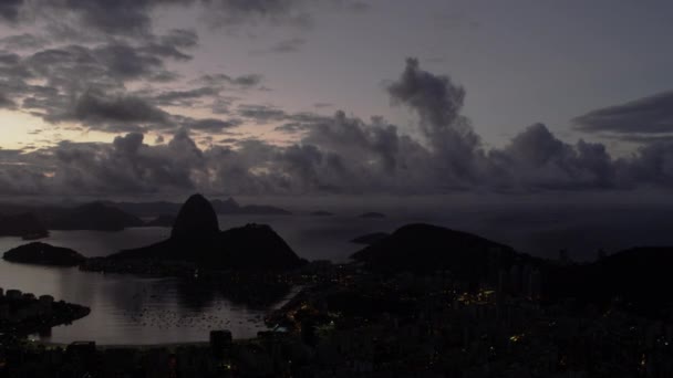 リオデジャネイロ ブラジルの都市間で右から左へパンのショット 夕暮れに 街の明かりが見える 市内と湾を取る下部フレームの半分と山や空は 残りの半分を埋める — ストック動画