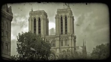 Ünlü Notre Dame Katedrali tarafında ağaçlar dramatik bulut arka plan ve yan başka bir Paris üzerinde solda Fransa bina üzerinde yükselir. Vintage stilize video klip.