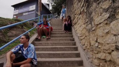 Rio De Janeiro, Brezilya - 23 Haziran 2013: yavaş hareket izleme atış bir favela Rio de Janeiro, Brezilya için merdivenlerde oturan insan