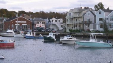 Rockport Harbor atış demirli tekneler ve alacakaranlıkta oceanside binalar ile.