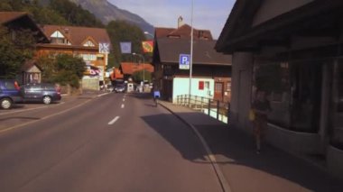 Arka planda İsviçre alpleri ile Brienz, İsviçre'de Alder de la Gare otel ve restoran geçmiş bir bycyicle aşağıdaki bir panning çekim.