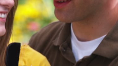 Genç bir adam güzel bir bahçe içinde genç bir kadın için öneriyor.