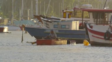 Rio de Janeiro - 19 Haziran 2013: Guanabara Körfezi'nde altın güneş ışığında kürek çekerek bir adamın yavaş hareketi.
