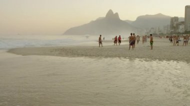 Rio De Janeiro-Haziran16, 2013: Brezilya'nın Rio de Janeiro şehrindeki Ipanema plajında bir daire çizen ve birbirlerine futbol topu tekmeleyen gençlerin yavaş çekim takibi.