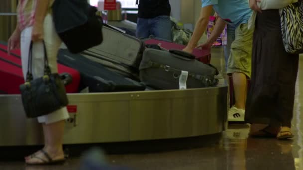 Ein Mann Nimmt Seine Handtasche Vom Band Während Andere Der — Stockvideo