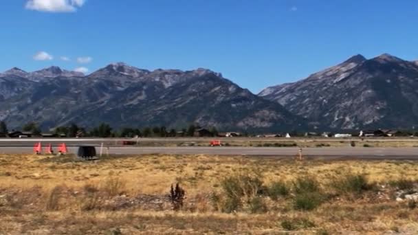 Jackson ワイオミング州の空港のショットをパンします 右から左へ 最初の山と 飛行機と空港の建物を示すからカメラのパン — ストック動画