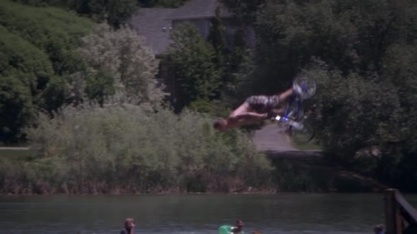 자전거에 호수에는 제비를 소년의 슬로우 카메라는 Dock 아래로 따른다 Backflips — 비디오