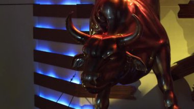 Las Vegas, Nevada'da bronz boğa heykeli ve arkasındaki ahşap ve neon duvar shot.