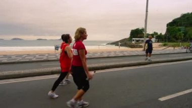Rio De Janeiro - Haziran 2013 yaklaşık: ağır çekim dolly atış üç kadın Rio de Janeiro, Brezilya için Ipanema Plajı yakınındaki yürüyüş