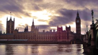 Westminster Sarayı ve Thames Nehri'nin alacakaranlıkta sabit bir zaman atlamalı çekimi. Gökyüzü hem bulutlu hem de parlak. Güzel çekim.