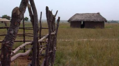 Geniş ön planda çit ile çimenli Hut shot