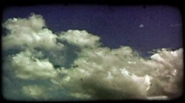 Beyaz ve gri bulutlar drift çerçevede alt kısmı boyunca ışık mavi gökyüzü ve arka planda diğer bulutlar ile hızlandırılmış. Vintage stilize video klip.