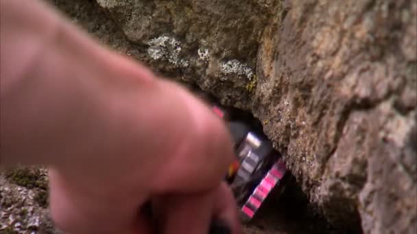拍摄的登山手把弹簧加载的凸轮装置放在岩石的裂缝 相机倾斜下来 露出更多的凸轮装置 — 图库视频影像