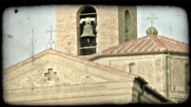 Bir çan kulesi İtalya çeşitli binaların arkasında bir kadeh. Vintage stilize video klip.