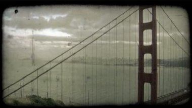 Kırmızı bir yüzünün Orta-yakın atış, iyi bilinen Golden Gate Köprüsü San Fransisco, California, uzak şehir görünür ve kabarık ile ek yükü gece karanlığında bulutlar. Vintage stilize video klip.