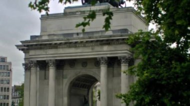 Hyde Park Corner Londra, İngiltere çerçeve tarafında yeşil ağaçlar ile gün boyunca Wellington Arch sabit görünümü.