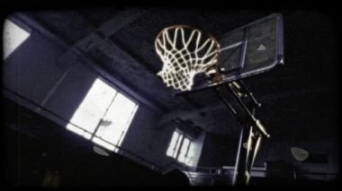 Beyaz bir basketboloyuncusunun orta açı atışı yavaş çekimde ters vuruş smaç yapıyor. Vintage stilize video klip.