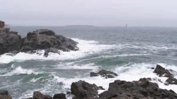 Panning Shot Uit Golven Breken Een Rotsachtige Kustlijn Naar Het — Stockvideo