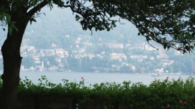 Orta atış ağaç silueti ile göl ve arka planda İtalya'da villa.